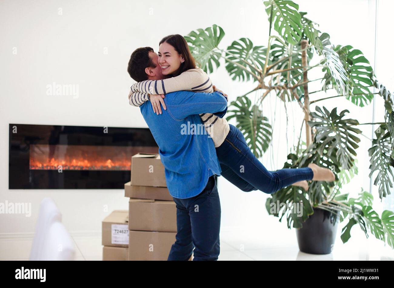 Happy couple with cardboard boxes hugging in new home. New home and happiness concept. Mortgage for the family Stock Photo