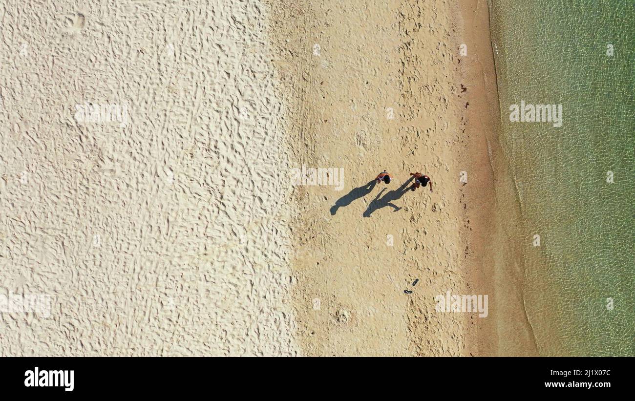 An aerial view of two beautiful girls walking on the beach in Ko Samui