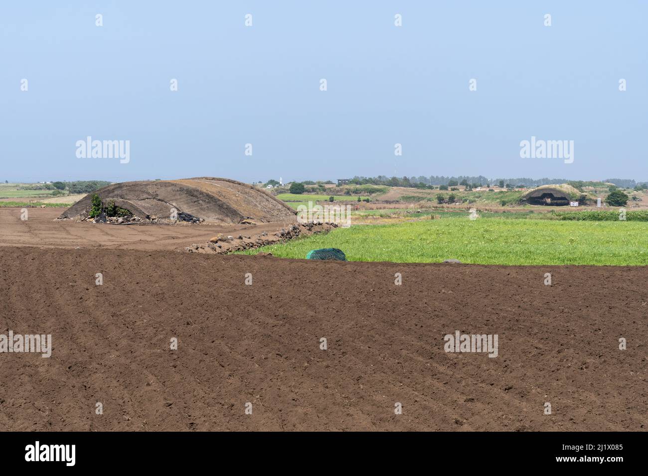 World War II era aircraft bunkers at Altteureu (Alddreu) Airfield in southern Jeju Island, South Korea, seen while hiking Jeju Olle Trail Route 10. Stock Photo