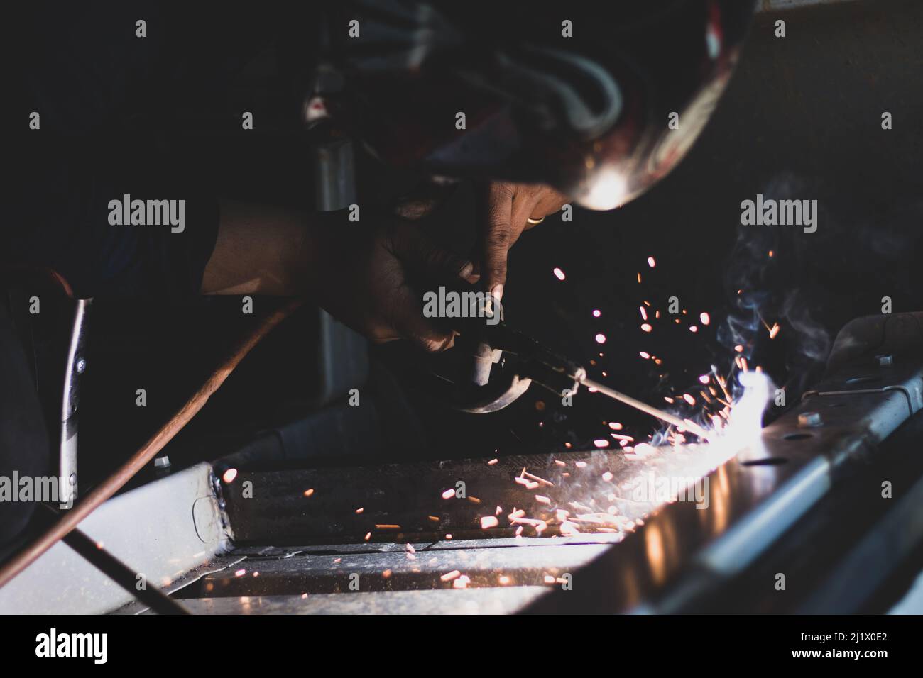 A closeup shot of a  metal fabricator making automotive welding with flames in a car factory Stock Photo