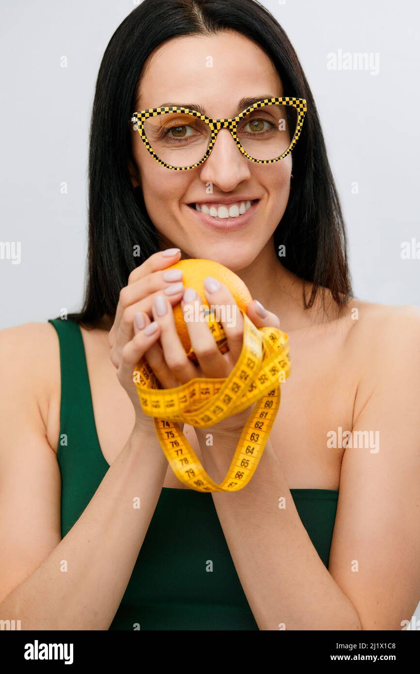 woman's hand holds a centimeter-long ribbon and lemon fruit. The ...
