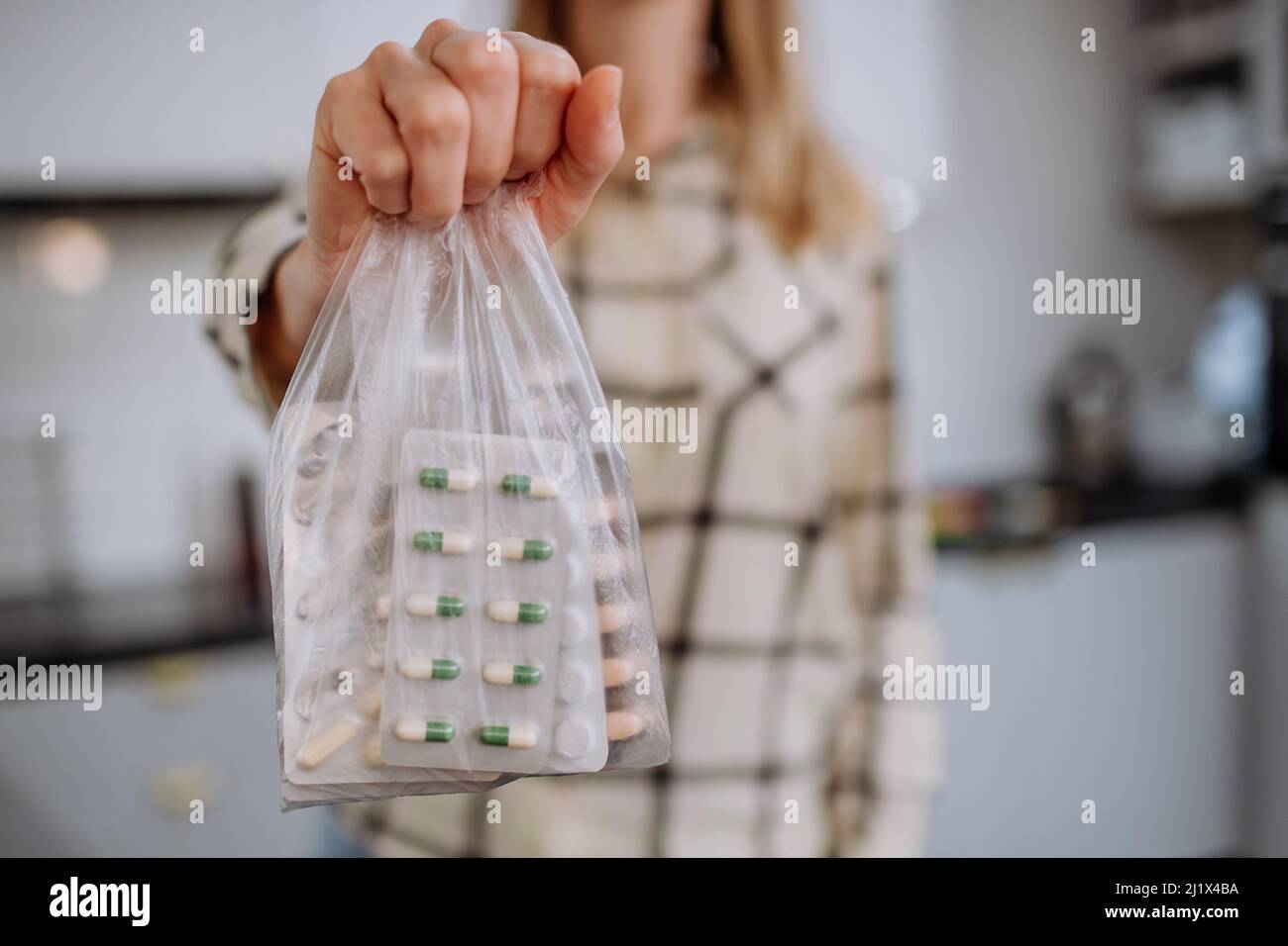 Woman's hand holding expired pills ready to recycle. Stock Photo