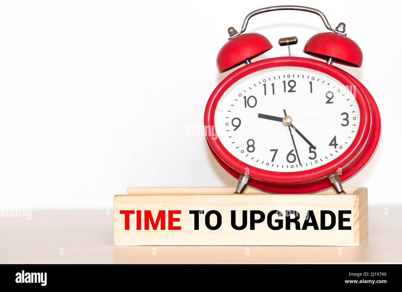 time to upgrade on postit stuck to a wall clock Stock Photo Alamy