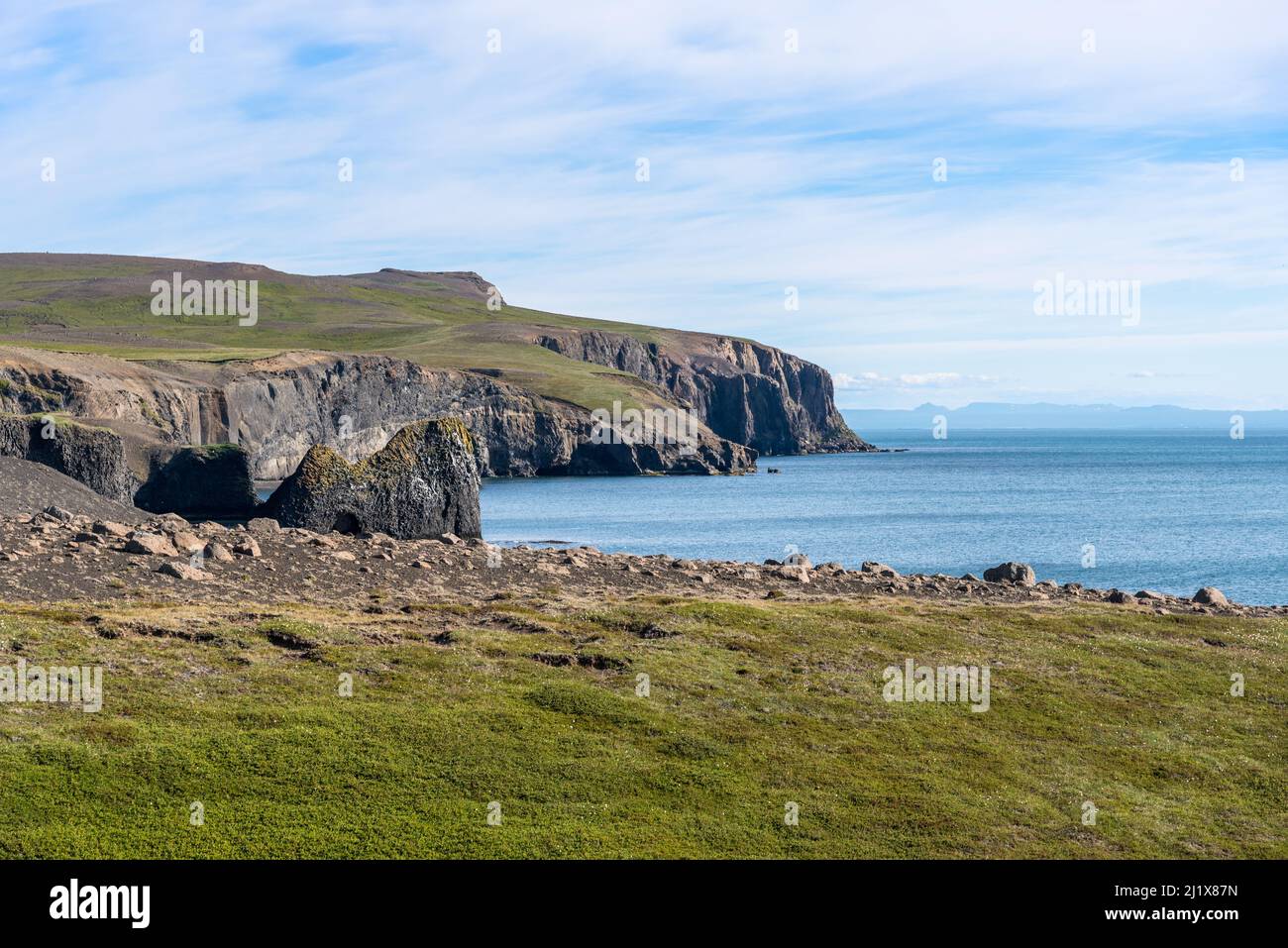 Rocky cliffs allong the coast of Norther Iceland on a partly cloudy summer day Stock Photo