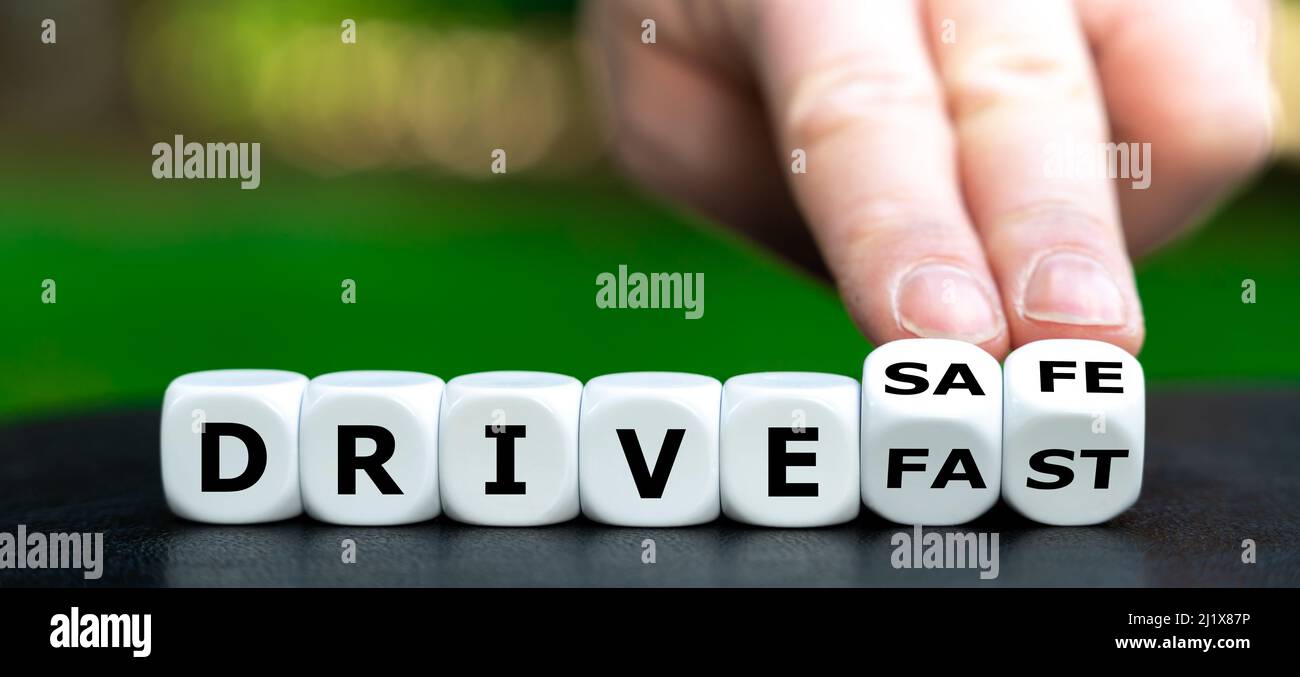 Hand turns dice and changes the expression 'drive fast' to 'drive safe'. Stock Photo