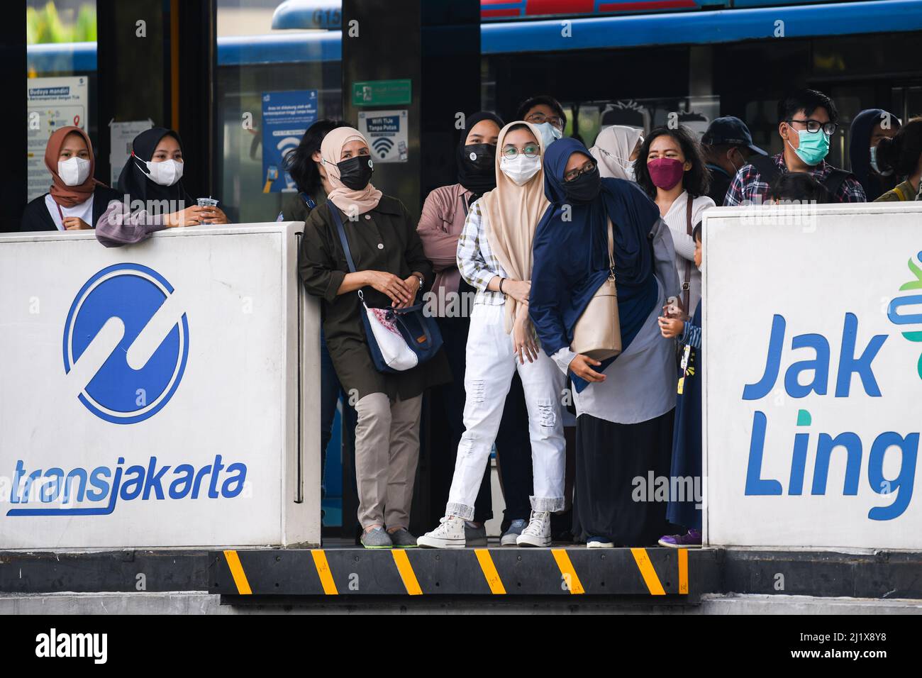 Jakarta, Indonesia. 27th Mar, 2022. People wearing masks wait for buses at a bus stop in Jakarta, Indonesia, March 27, 2022. Indonesia has registered more than 6 million cases of COVID-19 since the first case was confirmed in the country in March 2020. On Monday, the Health Ministry reported that the coronavirus cases across the archipelago rose by 2,798 within the past 24 hours to 6,001,751 with the death toll adding by 104 to 154,774. Credit: Xu Qin/Xinhua/Alamy Live News Stock Photo