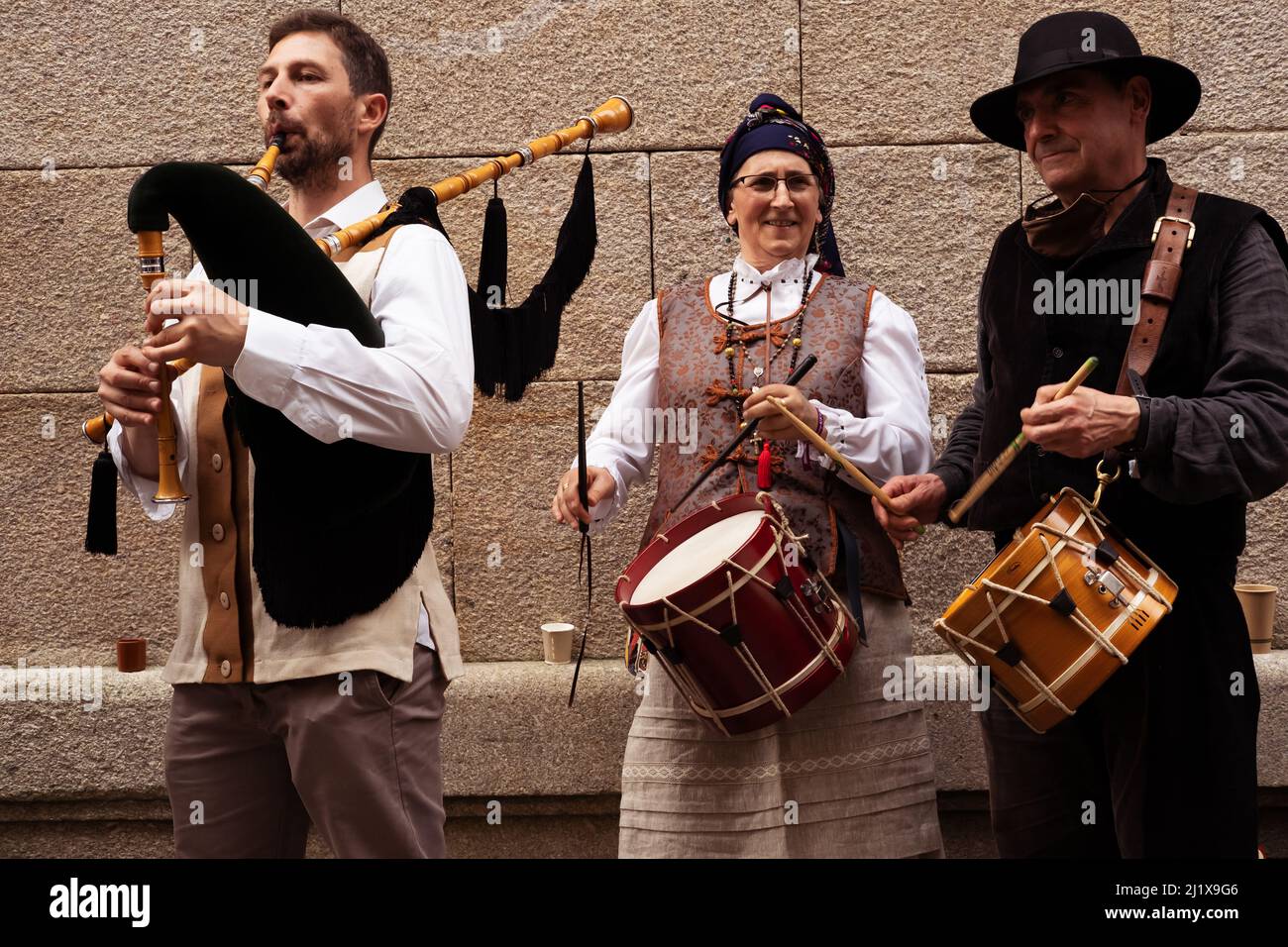 Vigo, Galicia, Spain, March 26 2022: A woman and two men play folk music wearing traditional costumes from Galicia Stock Photo