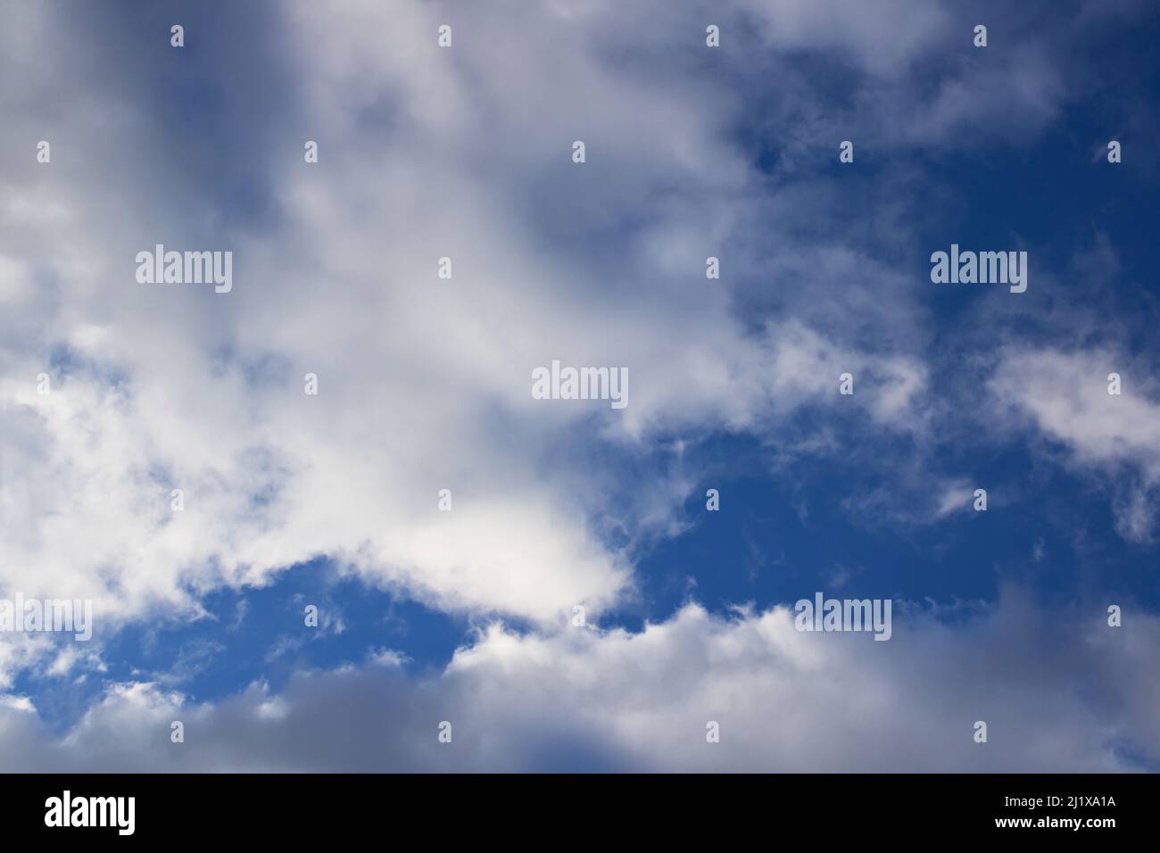 Fluffy clouds in the bright blue sky, nature background Stock Photo - Alamy