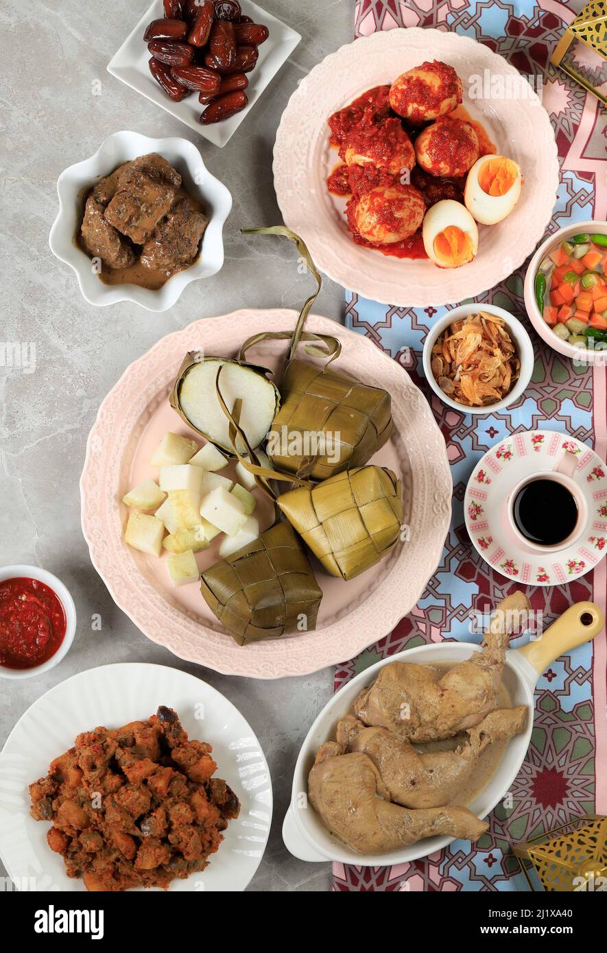 Ketupat Lebaran Menu with various Side Dish,  Traditional Celebratory Dish of Rice Cake, Popular Served During Eid Celebrations Top View Stock Photo