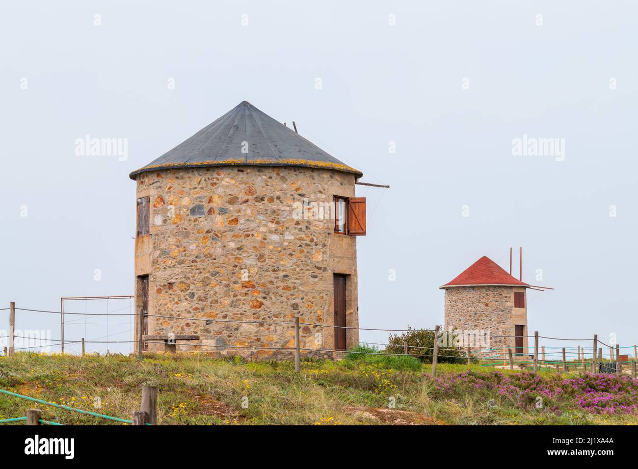 Hiking in Portugal on northwest coast in Apúlia beach near to windmills, tourism accommodation on windmills. Windmills near the ocean. Walking in Portugal. Stock Photo