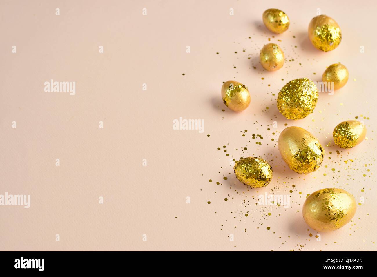 Easter eggs with gold sequins on a beige background.  Stock Photo