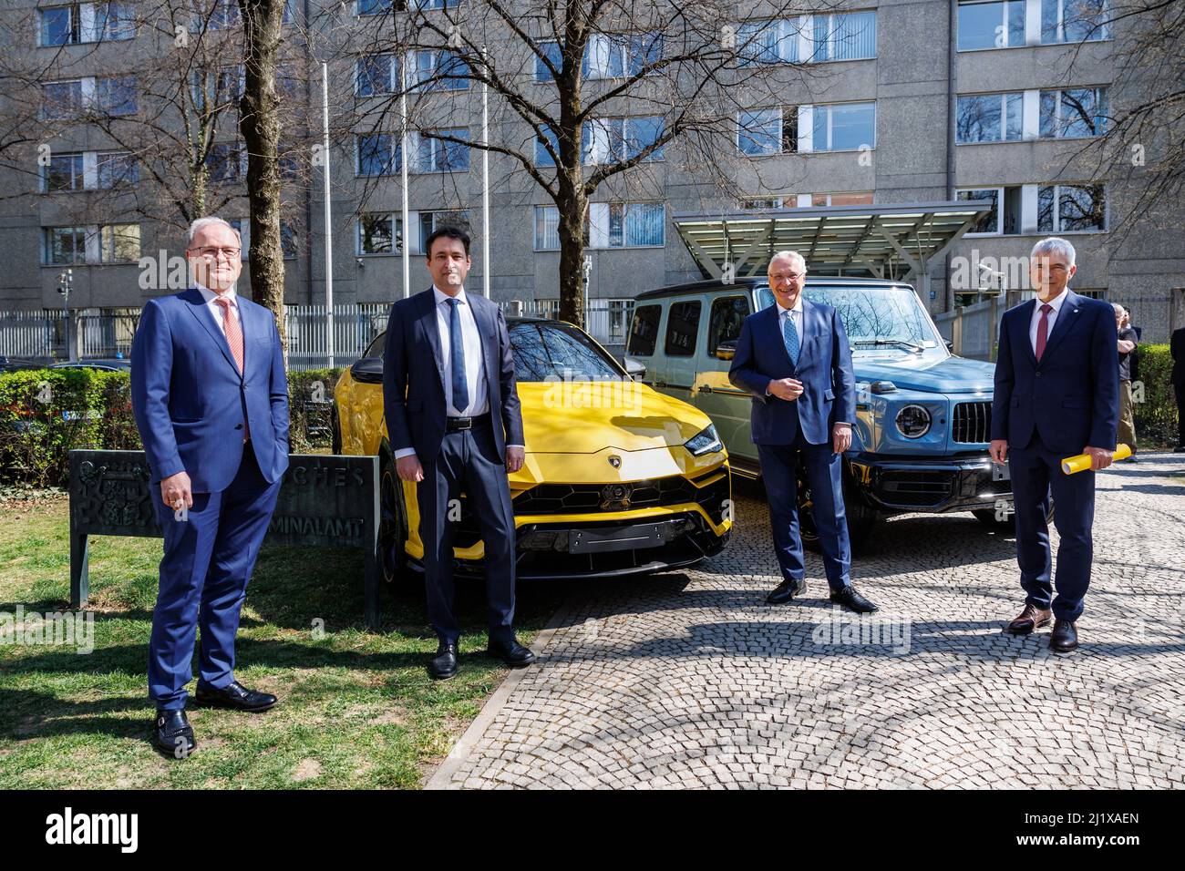 28 March 2022, Bavaria, Munich: Reinhard Röttle, Attorney General (l-r), Georg Eisenreich (CSU), Minister of Justice of Bavaria, Joachim Herrmann (CSU), Minister of the Interior of Bavaria, and Guido Limmer, in Swabia South/West, stand in front of a Lamborghini and a Mercedes G-Class seized during the 'Mulino' investigation prior to a press conference to provide information on current developments in the fight against organized crime in Bavaria. The vehicles originate from an investigation against members of the Italian mafia organization 'Ndrangheta', who sold the vehicles several times via a Stock Photo