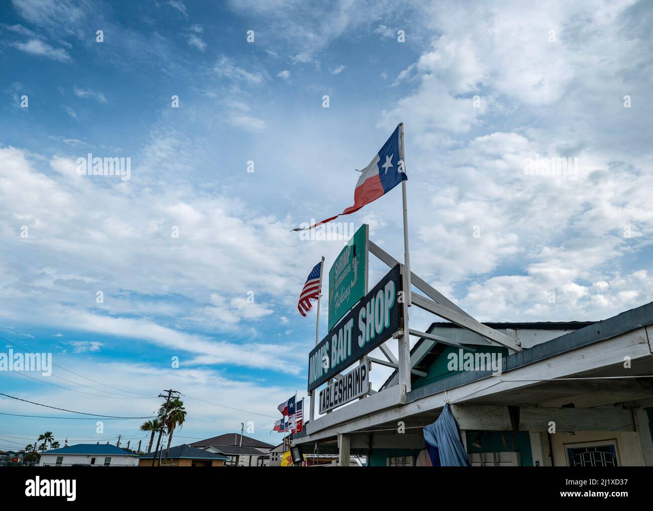 ROCKPORT, TX - 3 FEB 2020: MOMS BAIT SHOP store front sign and flags with clouds and blue sky in background. A popular place for fresh shrimp. Stock Photo