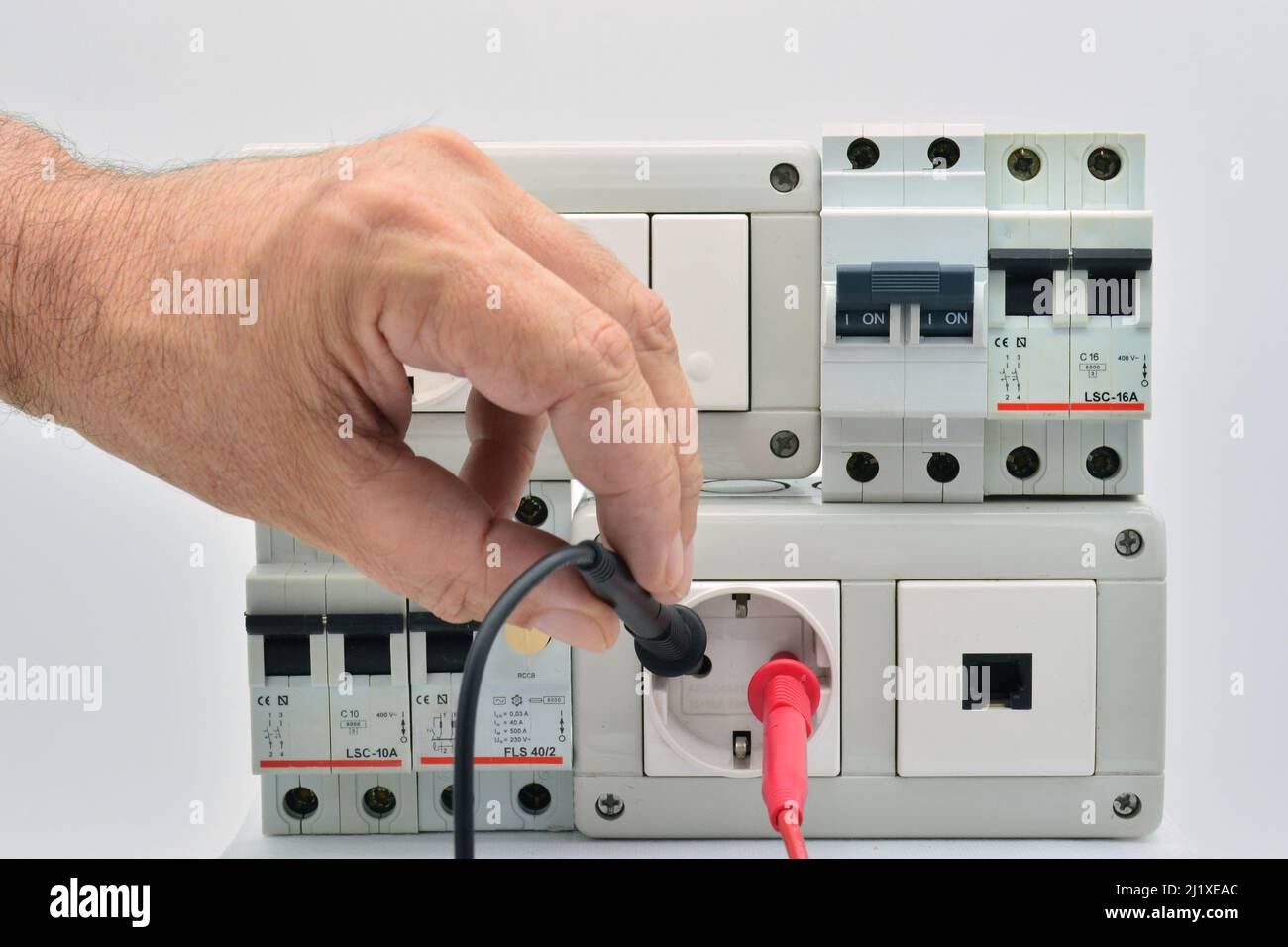 Midiendo electricidad en un cuadro eléctrico con magneto-térmico, enchufes, interruptores, toma de telefono y diferencial Stock Photo