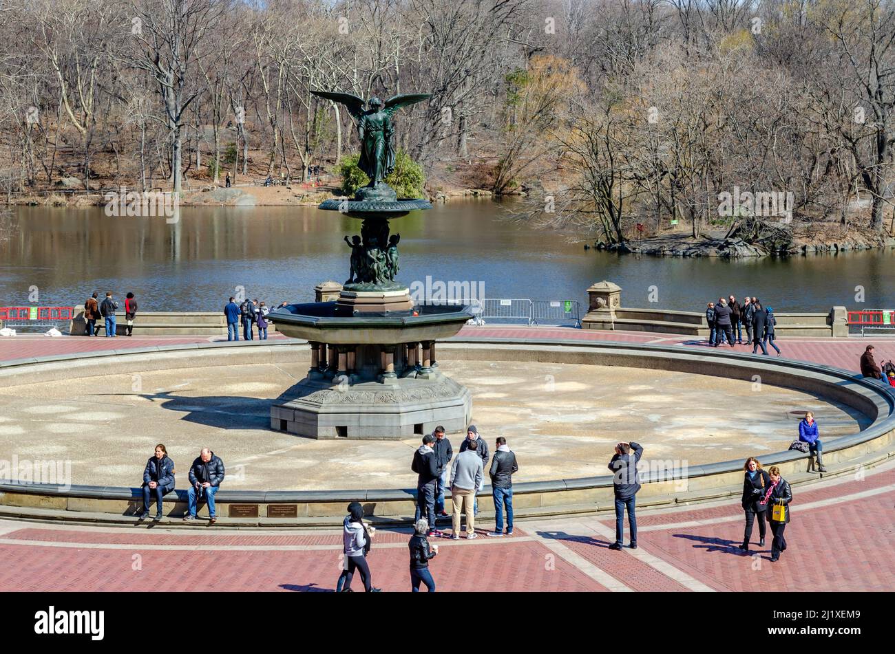 Bethesda Fountain with Angel of the Waters Sculpture with people walking and standing around the fountain, lake in the background Central Park New Yor Stock Photo