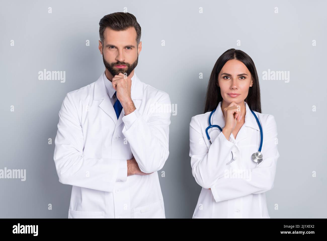 Photo of ponder pensive two doctors wear white coats hands arms chins