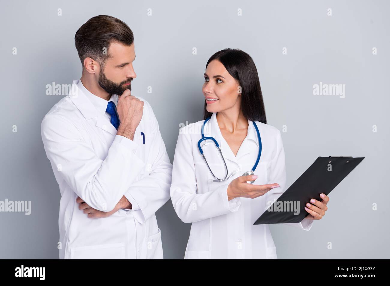 Photo of smart ponder two doctors wear white coats talking looking each