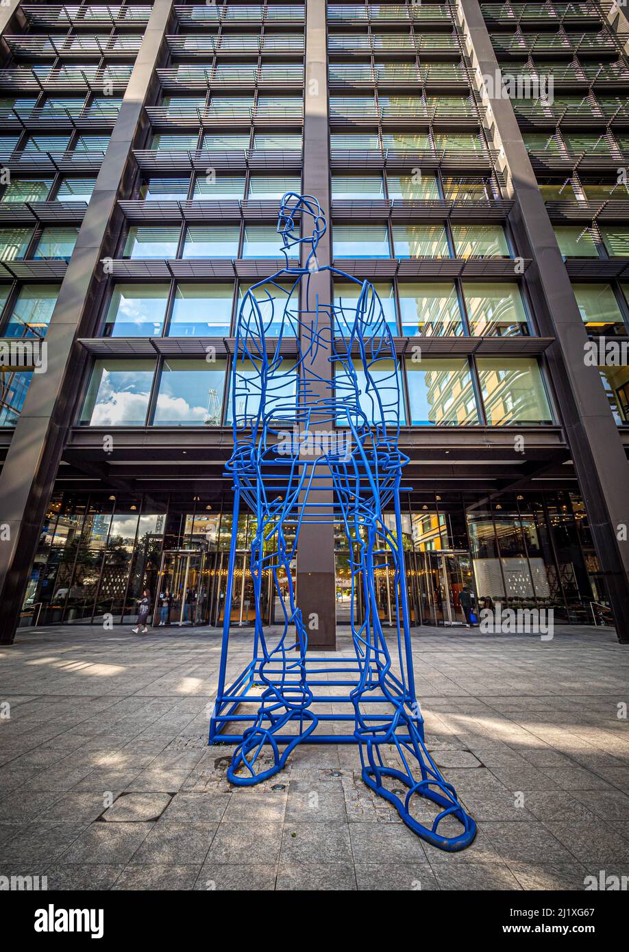 In Anticipation: Ultra-marine blue steel large-scale sculpture of a man situated in the piazza at Principal Place. London. UK Stock Photo