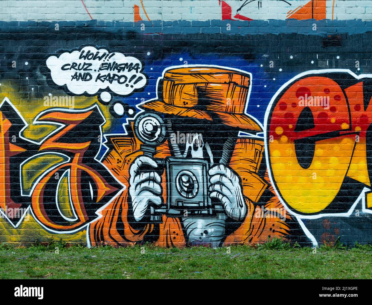 Colourful graffiti of a paparazzo on the railway walls seen from Station Park, Spitalfields, London. Stock Photo