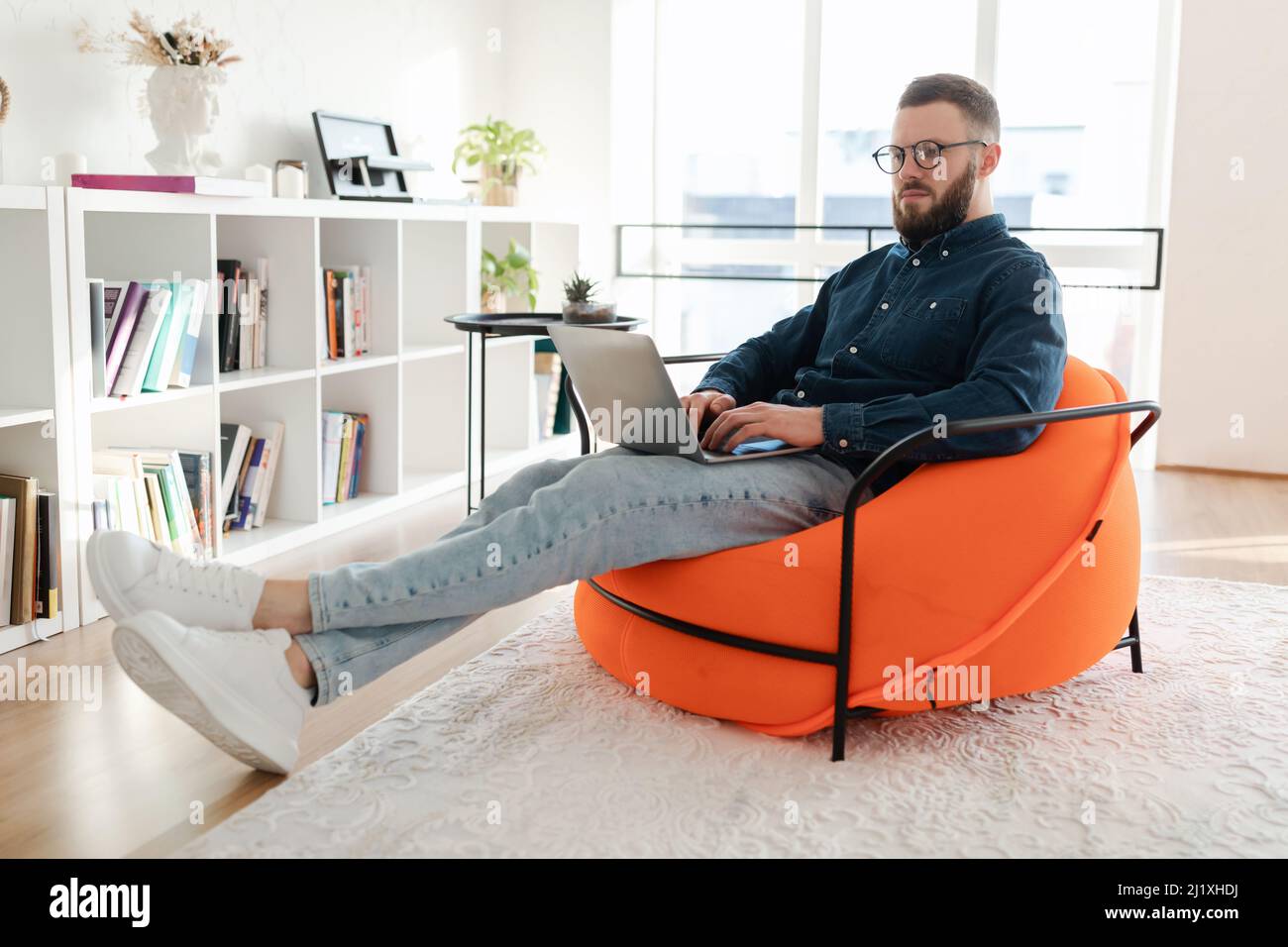 Freelancer Guy Using Laptop Working Online Browsing Internet Sitting Indoors Stock Photo