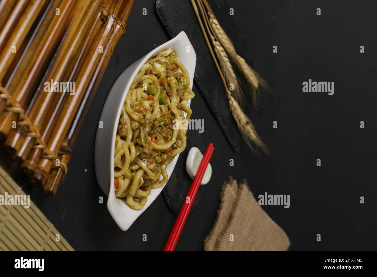 A rotated view of a plate full of Japanese noodles with meat and vegetables Stock Photo
