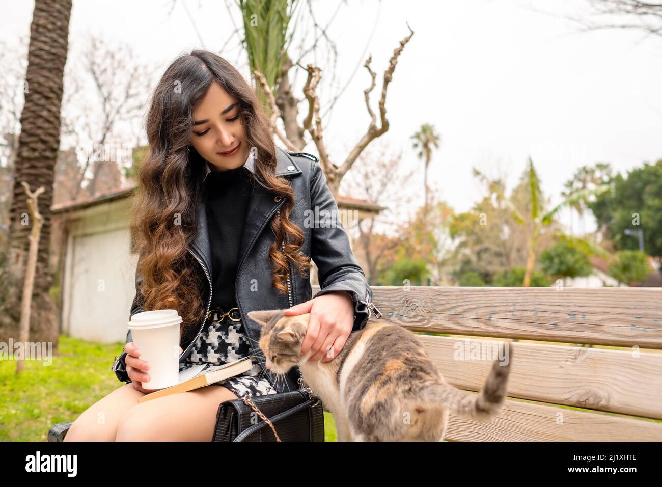 Animal lover young businesswoman caresses to cat. Loving animals with positive feelings. Stock Photo