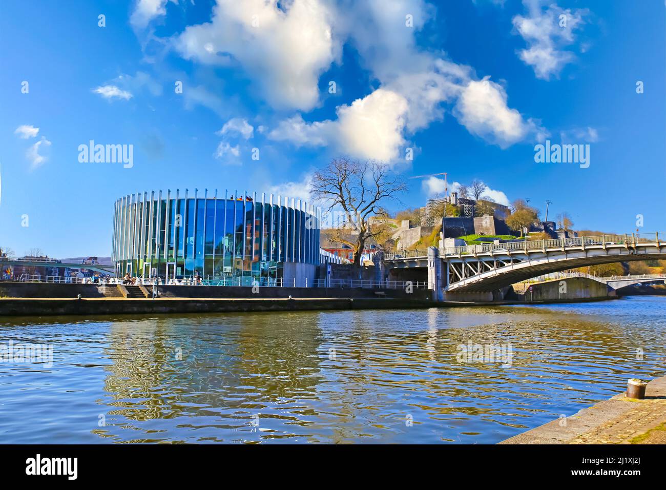Namur, Belgium - March 9. 2022: View on confluence of river meuse and sambre with bridge, modern restaurant building, blue morning sky Stock Photo