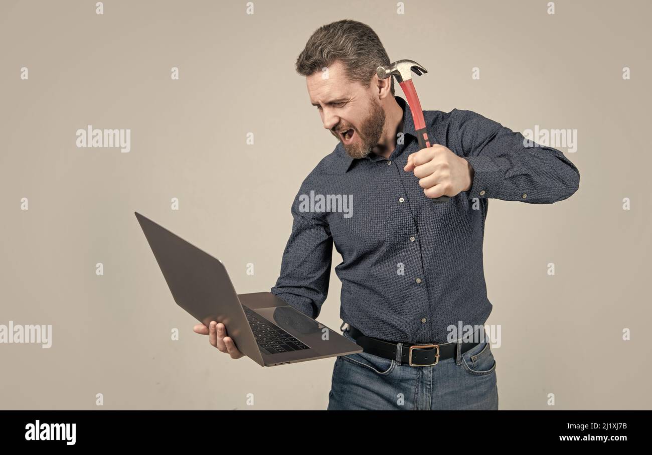 Spate of cyberattack. Hacker assaulting computer with hammer. Targeted cyberattack Stock Photo