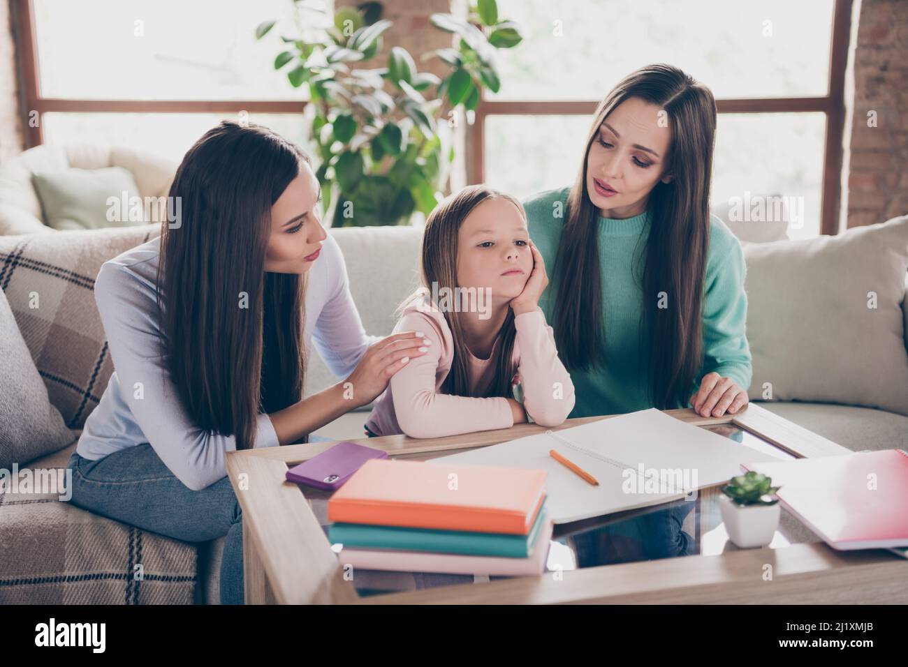 Photo of bored tired small lady hand cheek parents try comfort encourage education wear casual clothes home indoors Stock Photo