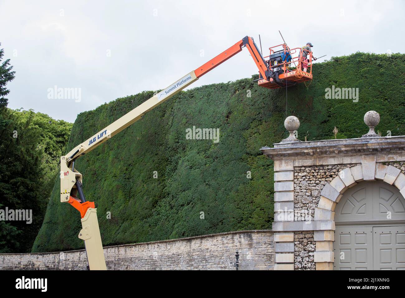 Workers from the Bathurst Estate, Cirencester use a cherry picker to give the estates 40ft high, 300 year old Yew hedge it's annual trim. The hedge is said to be the largest of it’s kind in the world and it can take up to 2 weeks to complete the job. Stock Photo