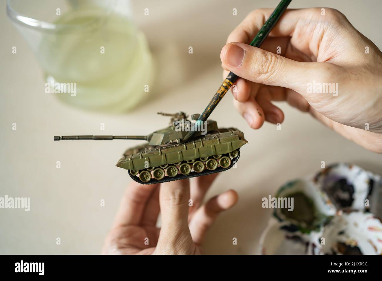 Painting tank plastic model with brush Stock Photo