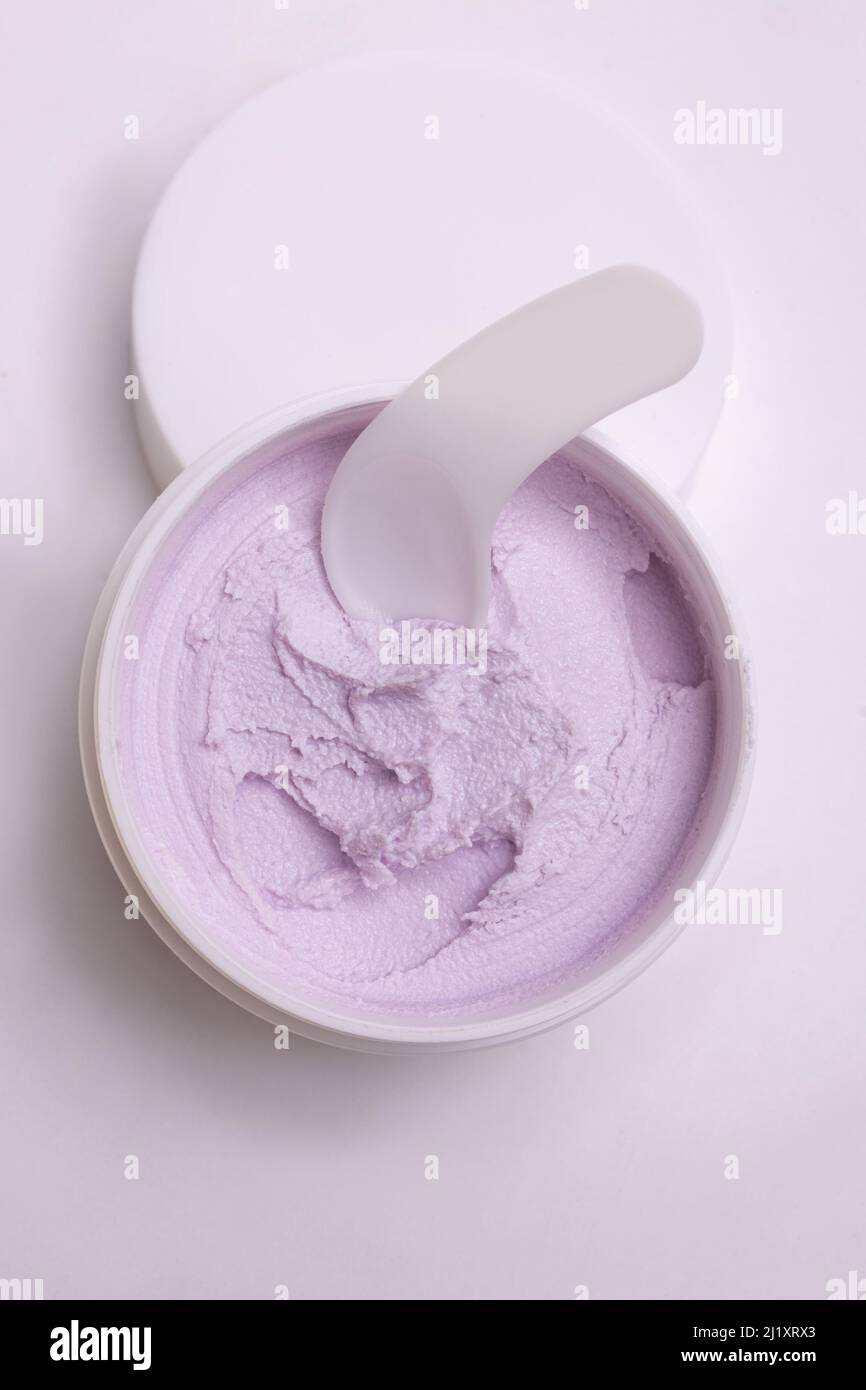 top view of a white jar of pink with a gentle face cream on a white background. Stock Photo