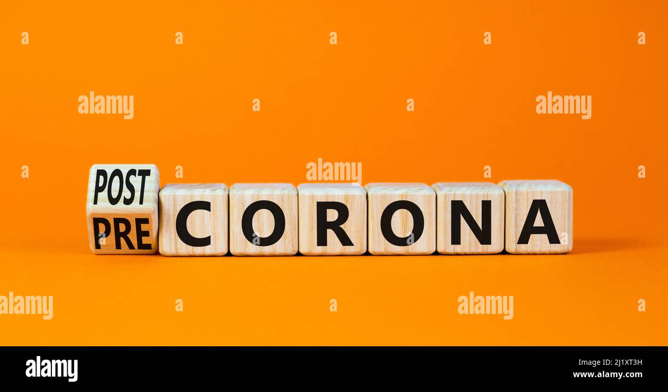 Covid-19 post or pre corona symbol. Turned wooden cubes and changed concept words Pre corona to Post corona. Beautiful orange background. Covid-19 pan Stock Photo