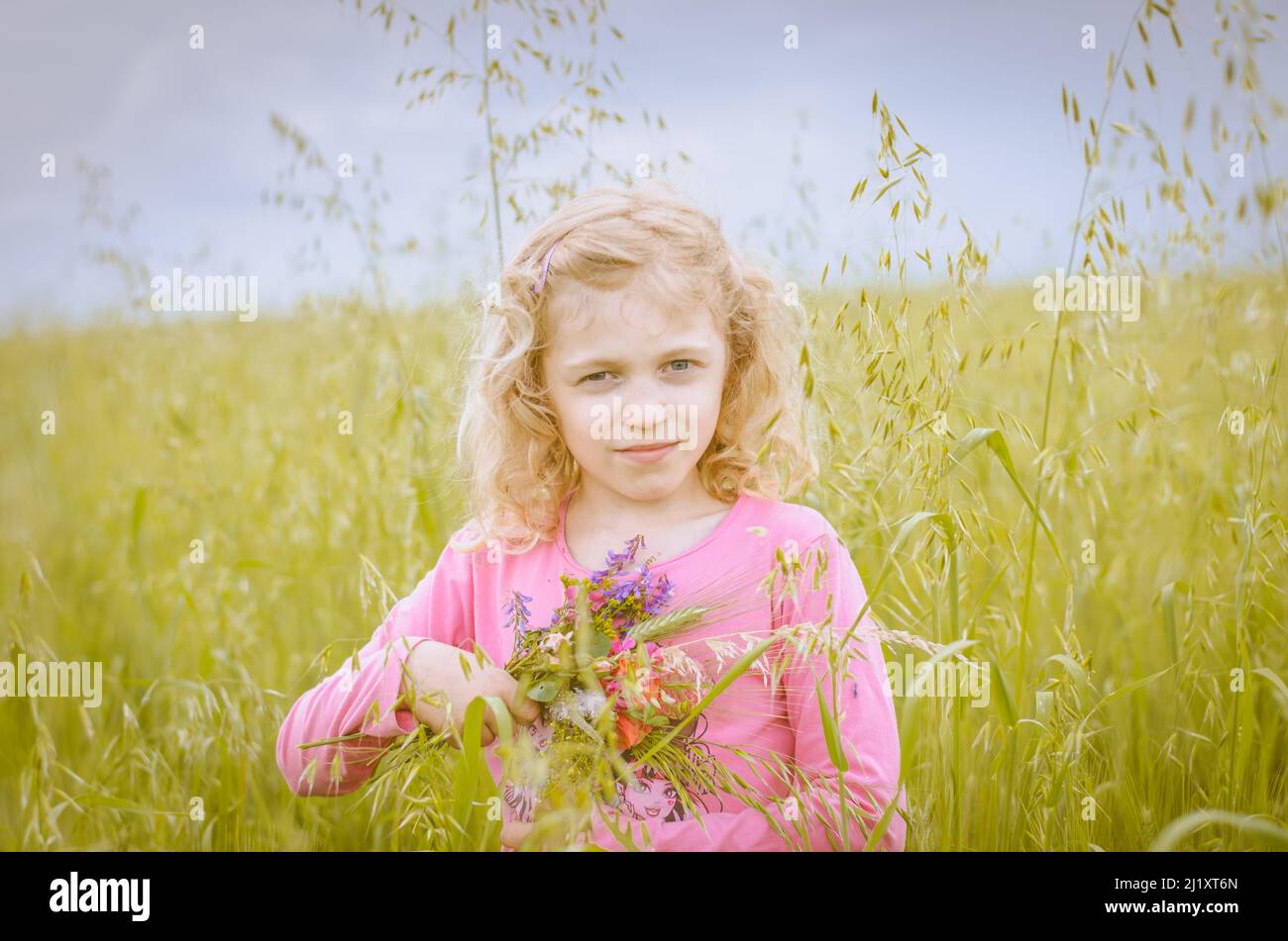 girl with long blond hair in spring green wheat field Stock Photo - Alamy