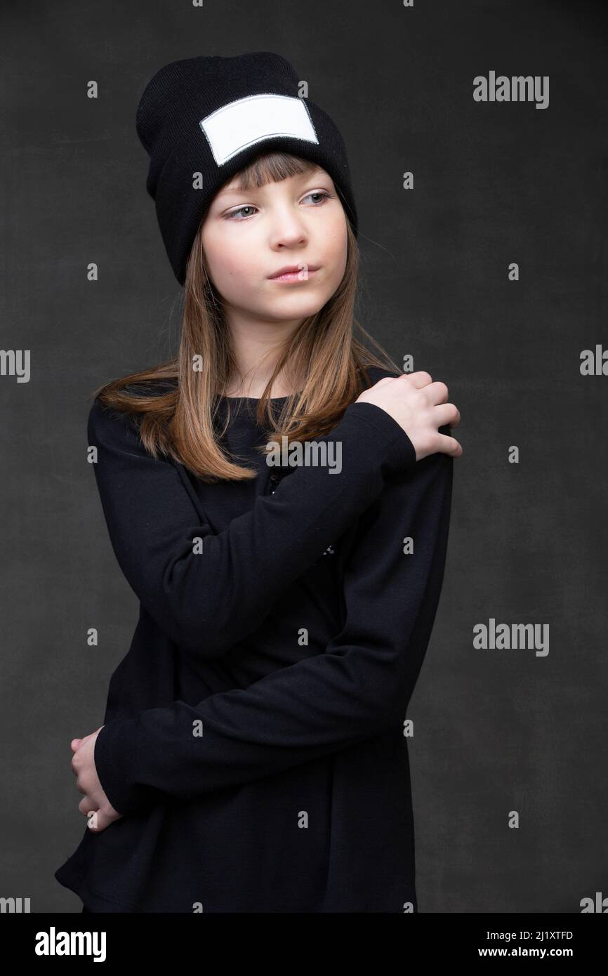 Beautiful little girl in a knitted hat on a dark background Stock Photo ...