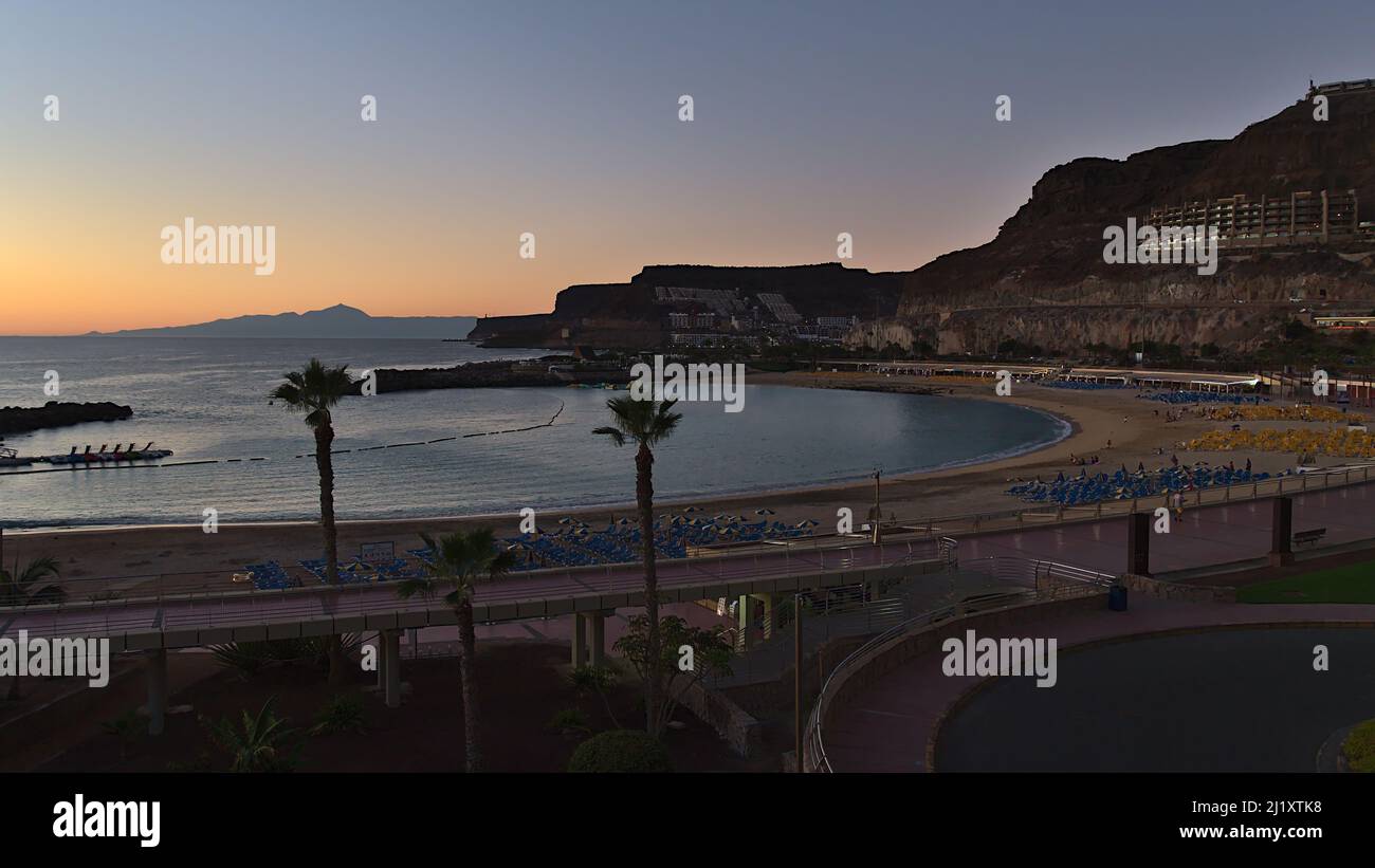 View of beach Playa de Amadores in holiday resort Puerto Rico on the southern coast of Gran Canaria, Canary Islands, Spain after sunset with Tenerife. Stock Photo