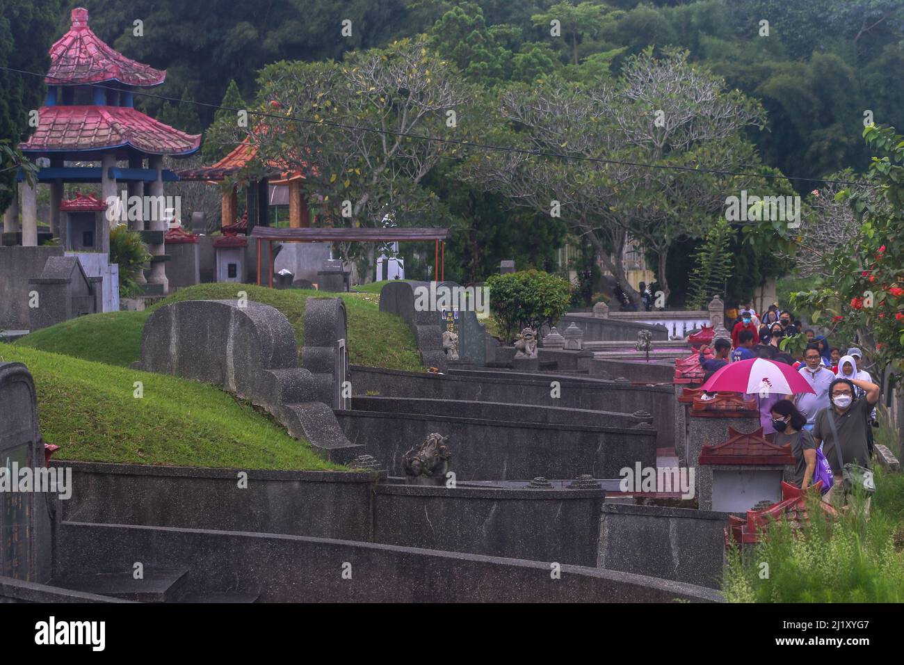 Indonesian ethnic Chinese gather in a cemetery to visit their loved ones during the Cheng Beng or Qingming Festival, also known as Tomb Sweeping Day, at a Chinese cemetery in Bogor, West Java, Indonesia on March 27, 2021. The Qingming Festival is an annual Chinese ethnic ritual to remember, honour, and pilgrimage to the ancestors grave according to Confucianism. Everyone prays in front of the ancestors, sweeps the tomb and prays with incense, money, paper prayers and various accessories, as an offering to the ancestors. (Photo by Andi M Ridwan/INA Photo Agency/Sipa USA) Stock Photo