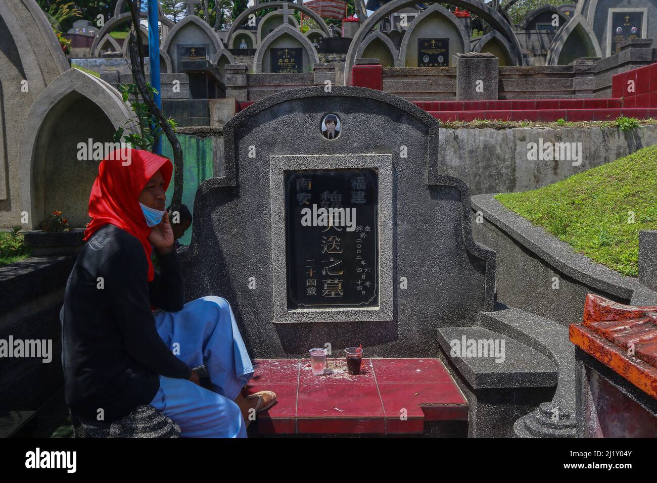A worker grave wait a Indonesian ethnic Chinese family to visit a tomb during the Cheng Beng or Qingming Festival, also known as Tomb Sweeping Day, at a Chinese cemetery in Bogor, West Java, Indonesia on March 27, 2021. The Qingming Festival or Cheng Beng is an annual Chinese ethnic ritual to remember, honor, and pilgrimage to the ancestors grave according to Confucianism. Everyone prays in front of the ancestors, sweeps the tomb and prays with incense, money, paper prayers and various accessories, as an offering to the ancestors. (Photo by Andi M Ridwan/INA Photo Agency/Sipa USA) Stock Photo