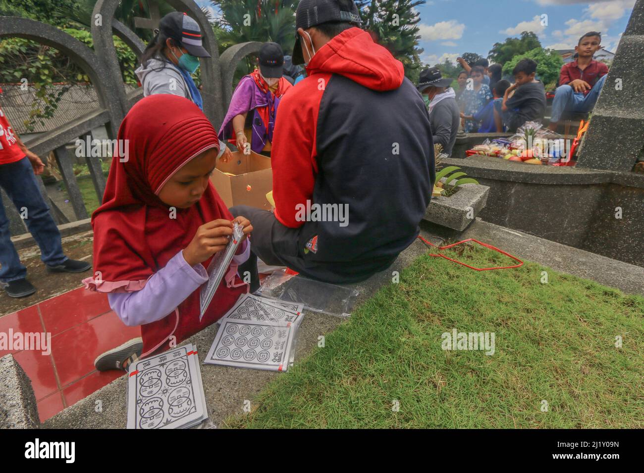 A young girl help prepare during the Cheng Beng or Qingming Festival, also known as Tomb Sweeping Day, at a Chinese cemetery in Bogor, West Java, Indonesia on March 27, 2021. The Qingming Festival or Cheng Beng is an annual Chinese ethnic ritual to remember, honor, and pilgrimage to the ancestors grave according to Confucianism. Everyone prays in front of the ancestors, sweeps the tomb and prays with incense, money, paper prayers and various accessories, as an offering to the ancestors. (Photo by Andi M Ridwan/INA Photo Agency/Sipa USA) Stock Photo