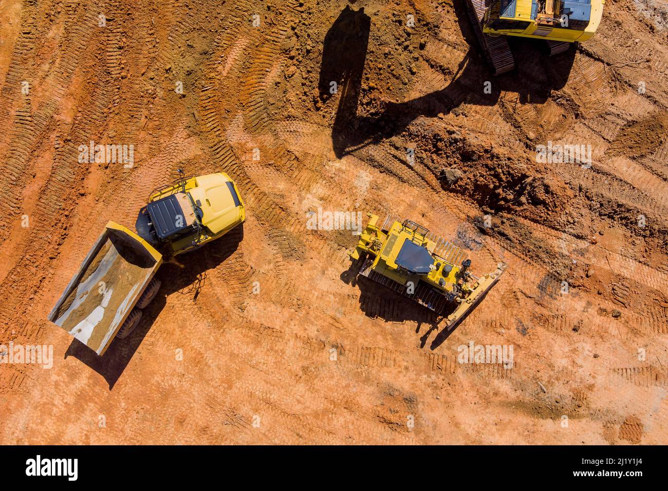 Digger on earthworks in excavator dig the trenche at construction site on arial view of earth moving heavy equipment Stock Photo