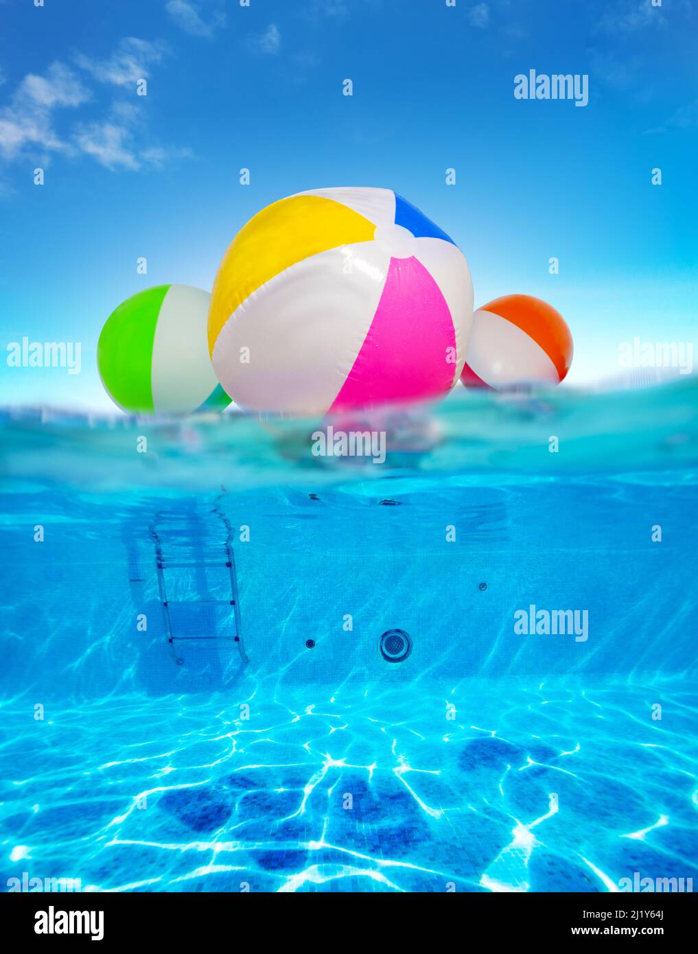 Inflatable balls float in water, split underwater pool image Stock