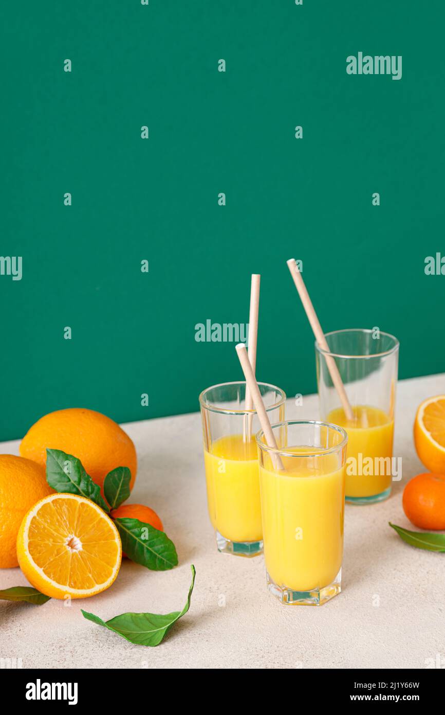 Freshly squeezed orange juice in a glasses with straws and fresh fruits