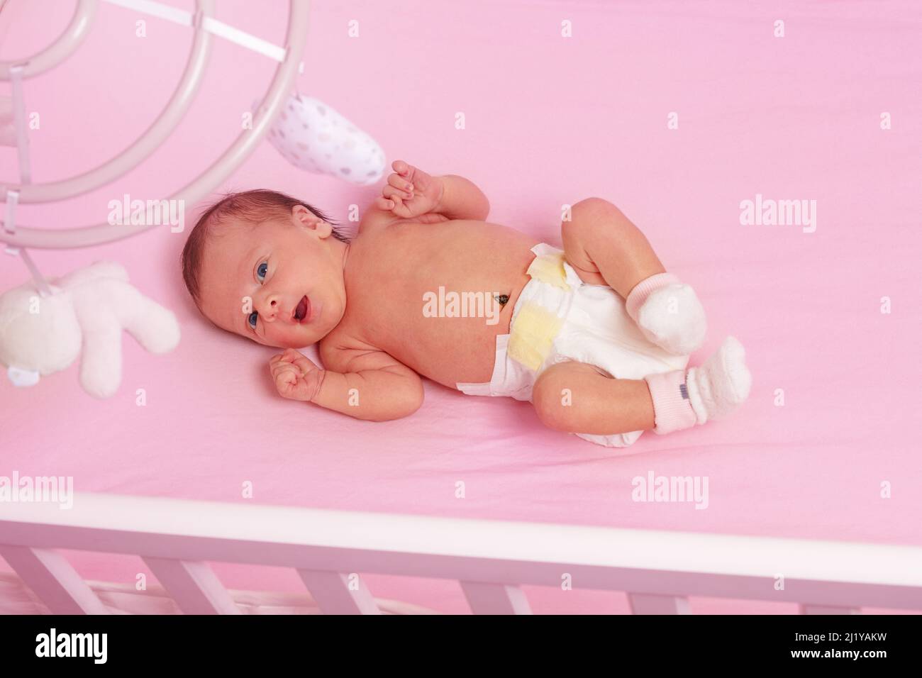 Newborn baby girl lay in the pink crib view from above Stock Photo Alamy