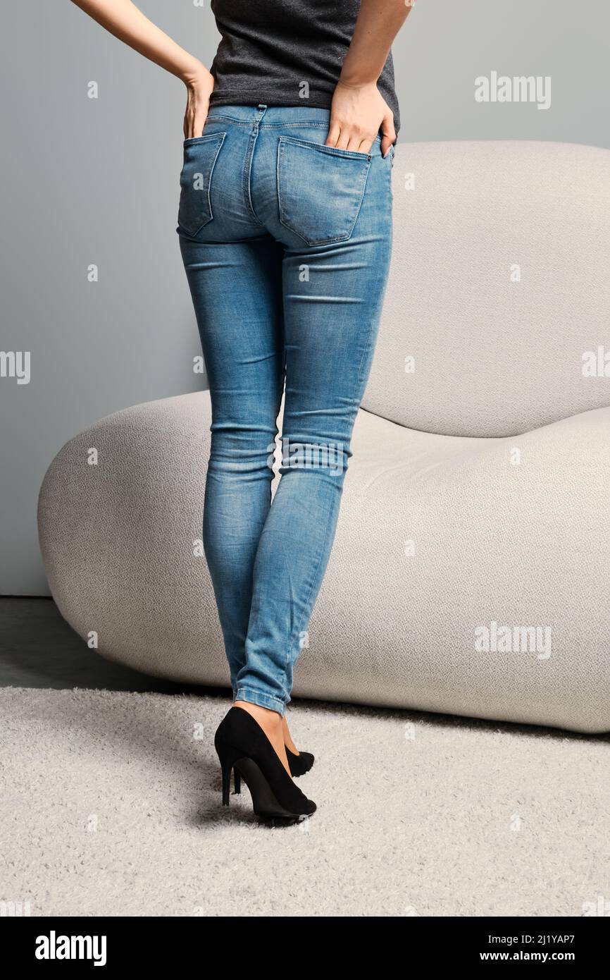 Cropped image of female legs in beige pantyhose and denim jeans standing  half turning back Stock Photo - Alamy