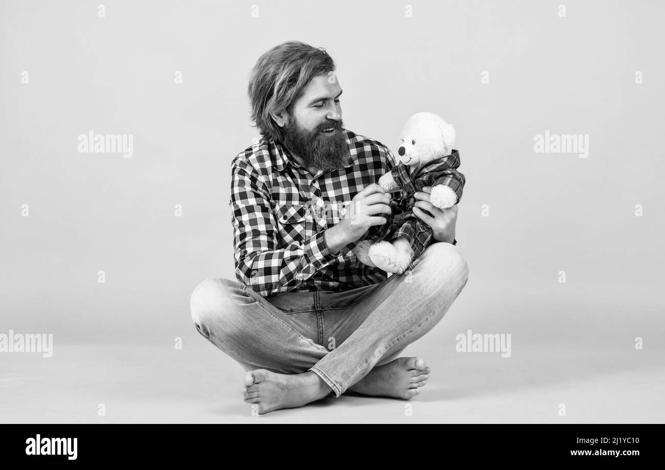 friendship. brutal mature hipster man play with toy. happy birthday. being in good mood. happy valentines day. cheerful bearded man hold teddy bear Stock Photo
