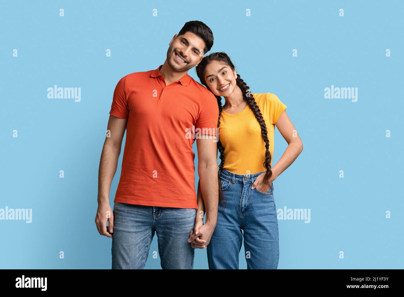 Portrait of happy middle eastern couple holding hands and looking at camera Stock Photo