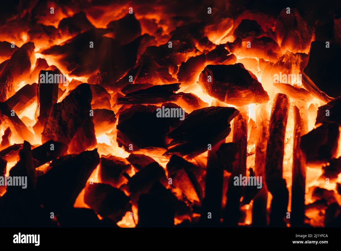 Abstract background of glowing coals in fireplace with fire flames. Burning flame background. Stock Photo