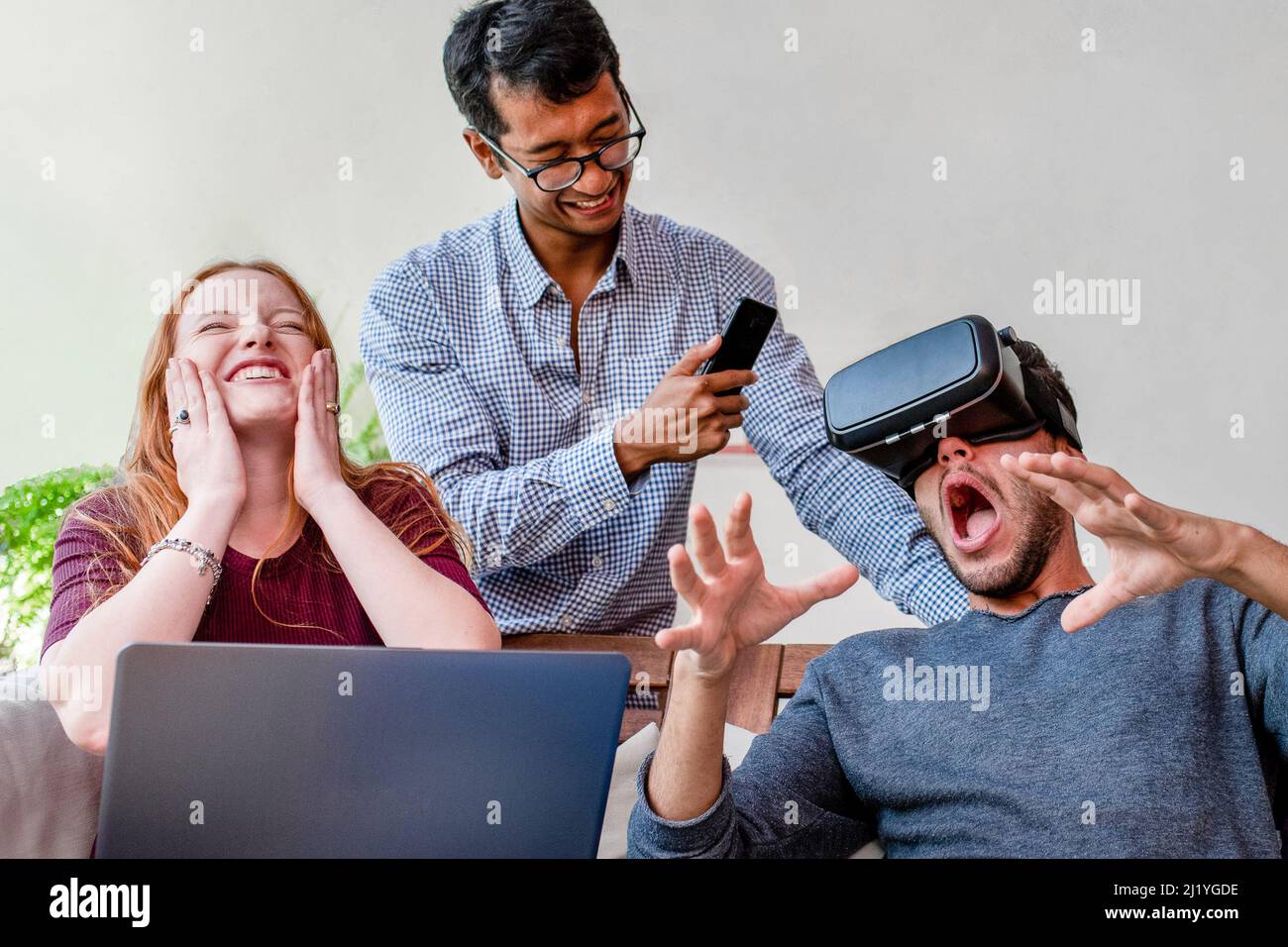 Young people having fun with new technology vr headset goggles, university students using a virtual reality game program Stock Photo