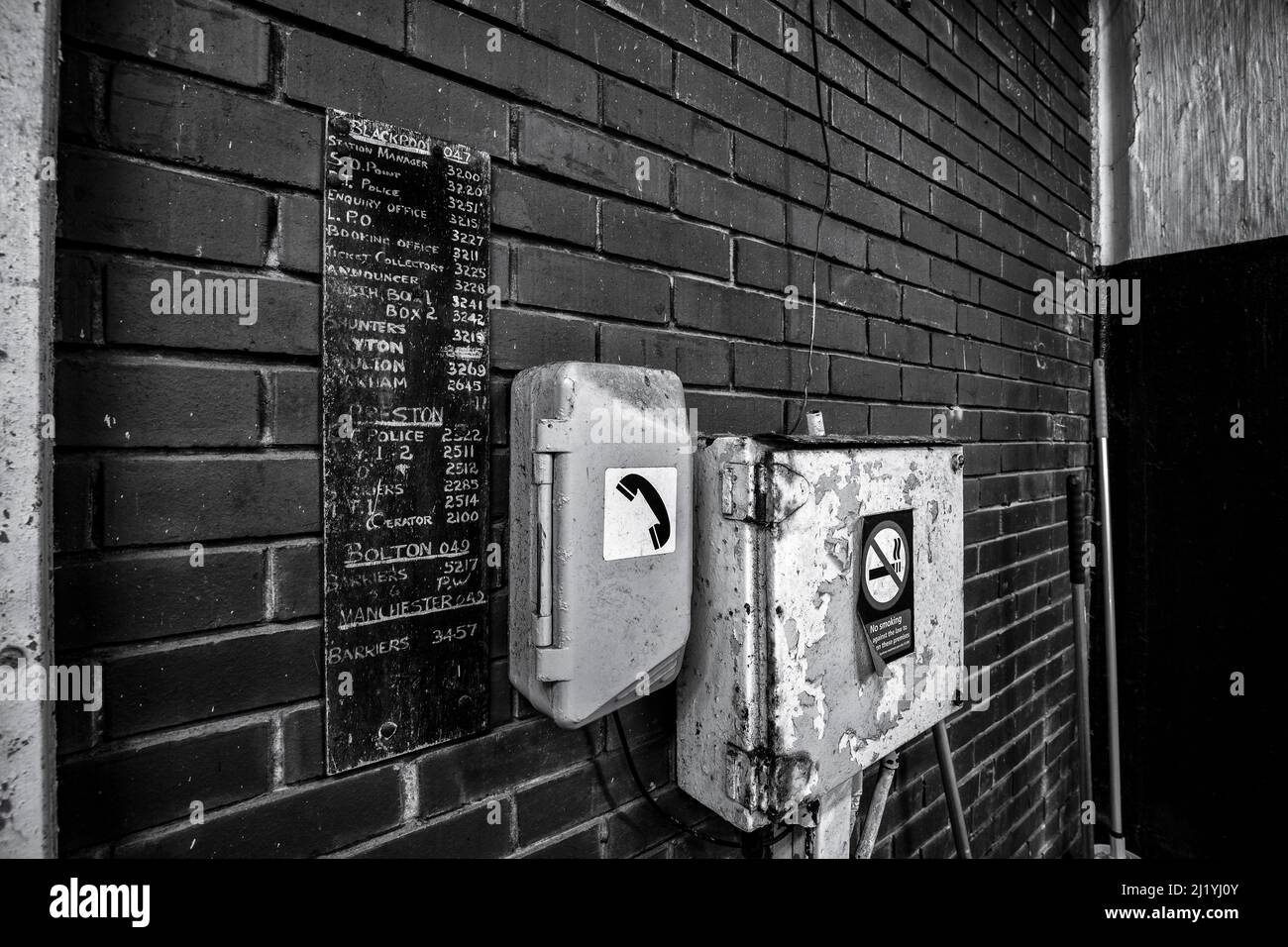 Blackpool North railway station. Telephone on the platform side of the concourse wall with a list of number for long closed places. Stock Photo