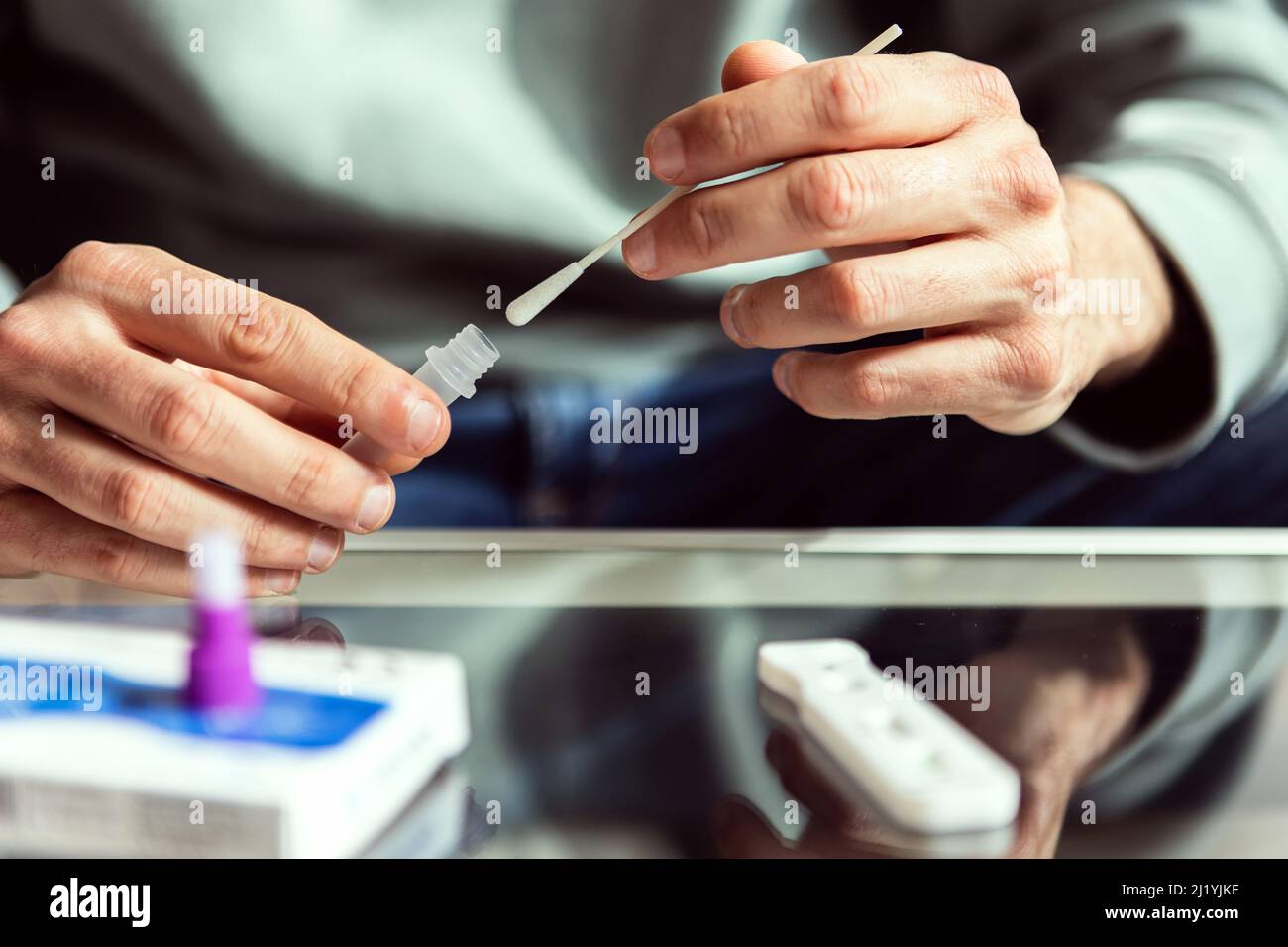 Young man doing self covid test at home Stock Photo